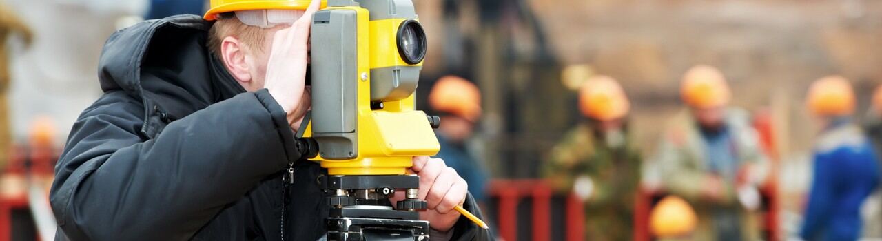 Surveyor using a total station on a job site